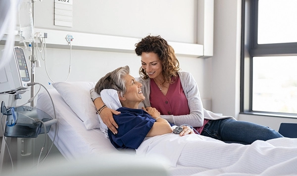 Frau kümmert sich um Mann im Krankenhausbett